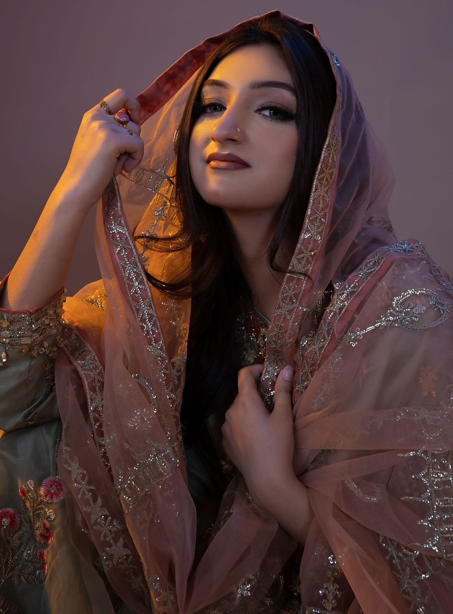 Bride raising a rust dupatta