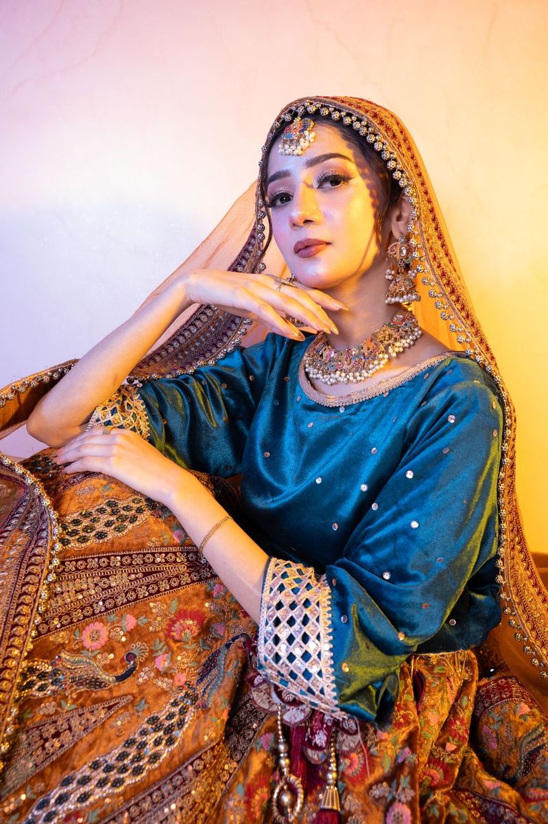 Bride in a teal and gold lehenga